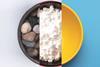 A bowl containing pebbles, another with powdered sugar and an empty bowl