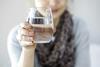 A lady holding a glass of clean drinking water