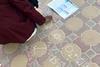 A student using chalk on the pavement to write chemical cycles