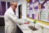 A lab technician heating an empty drinks can over a bunsen burner