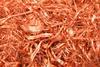 A close-up photograph of shiny copper shavings