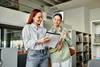 Teacher and a teenage girl in a library, both engrossed in a book