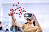 A girl uses VR glasses to see a molecular structure