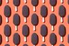 An image showing repeating chocolate ice cream bars on sticks against an orange background