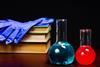 glass flasks with books and gloves