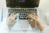 hands on a laptop with an overlay of chemical symbols