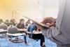 A teacher supervising students taking an exam with some empty seats