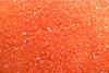 A full frame, close-up photograph of orange crystals of potassium dichromate