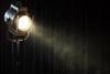 Vintage theater spot light on black curtain with smoke