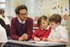 Male primary school teacher working with two young pupils