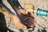 Tap in arid region with hand outstretched waiting for a drop of water