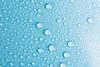 A close-up photograph of droplets of water on a bright blue surface