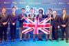 Four high school students in suits and ties with medals and a union jack flag