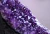 A close-up photograph showing a purple amethyst crystal