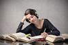 Smiling student listening to music while revising