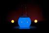 A round glass flask glowing blue