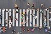 An overhead photo of people crossing the road in different directions