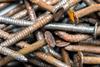 A close-up photograph of a pile of rusty metal nails