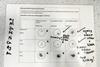 A laminated sheet for use in a microscale experiment for metal displacement reactions where small pieces of the metals are mixed in small droplets of ionic solutions and a student has also made observation notes on the sheet.