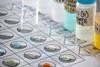 Close up of a microscale experiment where drops of metal ion solutions are mixed on a laminated grid