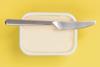 A tub of butter with a knife