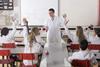 students in a chemistry lab with their hands up to answer a question asked by a teacher