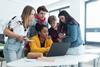 High school students gathered around a laptop