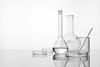 white background, glassware: flasks, beaker, stirring rod, petri dish