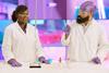 Two people in lab coats, safety goggles and latex gloves performing a titration