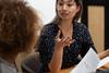female team leader in eyeglasses and colleague discussing working issues
