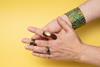 A person removing a copper ring to reveal a green stain on their skin