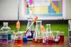 Assorted practical chemistry equipment. Different beakers have different coloured liquids in them.