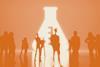 People standing a dark room with a giant lit conical flask symbol