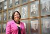 Professor Yellowlees standing in front of past portraits of RSC Presidents