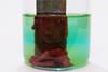 A piece of zinc placed in blue copper sulfate solution in a glass beaker, with a dark coating of copper resulting from the reaction that takes place
