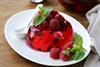 picture of a red jelly on a plate with raspberries on the top