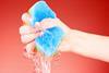 A hand squeezing water from a sponge