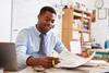 Photo of male teacher marking exam papers