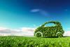 picture of a car made of green leaves driving through a field with a blue sky background