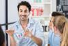 A male teacher animatedly talks to his younger teenager students about a molecule