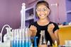 Girl smiling behind glassware in a school lab