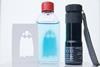 A torch, a stencil of a ghost and a glass bottle with a clear liquid that has the shape of a blue ghost within the liquid