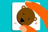 A close up of someone turning down a dial of a bear's face