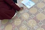 A student using chalk on the pavement to write chemical cycles