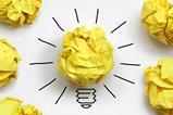 Screwed up piece of yellow paper with lines to make it look like a lit lightbulb
