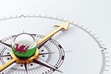 A digital illustration of a compass with a Welsh flag
