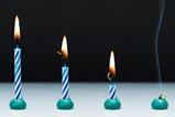 An image showing four stripey blue and white candles, all alight, from left to right, they show the progression of burning