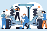 Mechanics using computers and tools to fix a car chassis