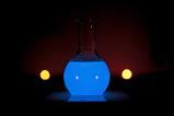 A round glass flask glowing blue