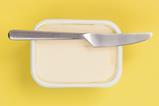 A tub of butter with a knife
